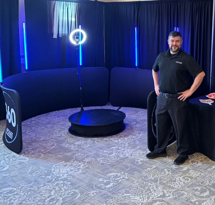 Apogee 360 video booth setup with rotating platform, ring light, and blue LED towers