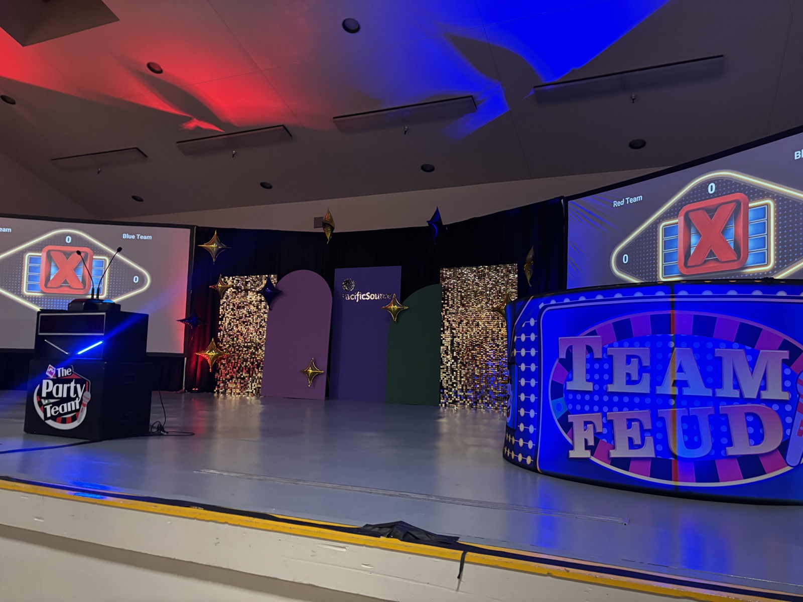 Team Feud game show stage in Salem with LED podium, dual scoreboards, and gold sequin backdrops at a PacificSource event