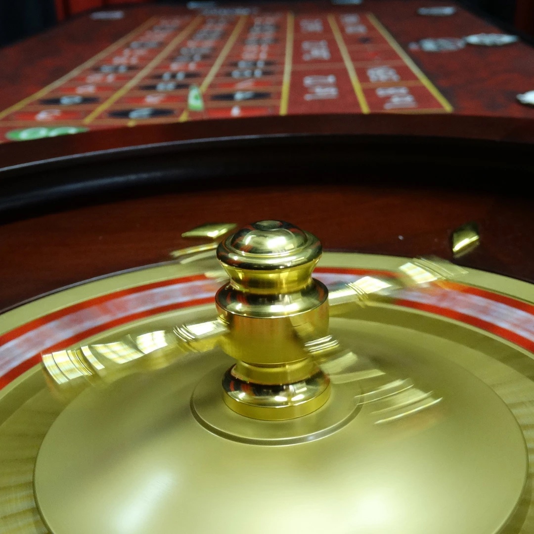 Close-up of a spinning roulette wheel with the red betting layout behind it at a casino party