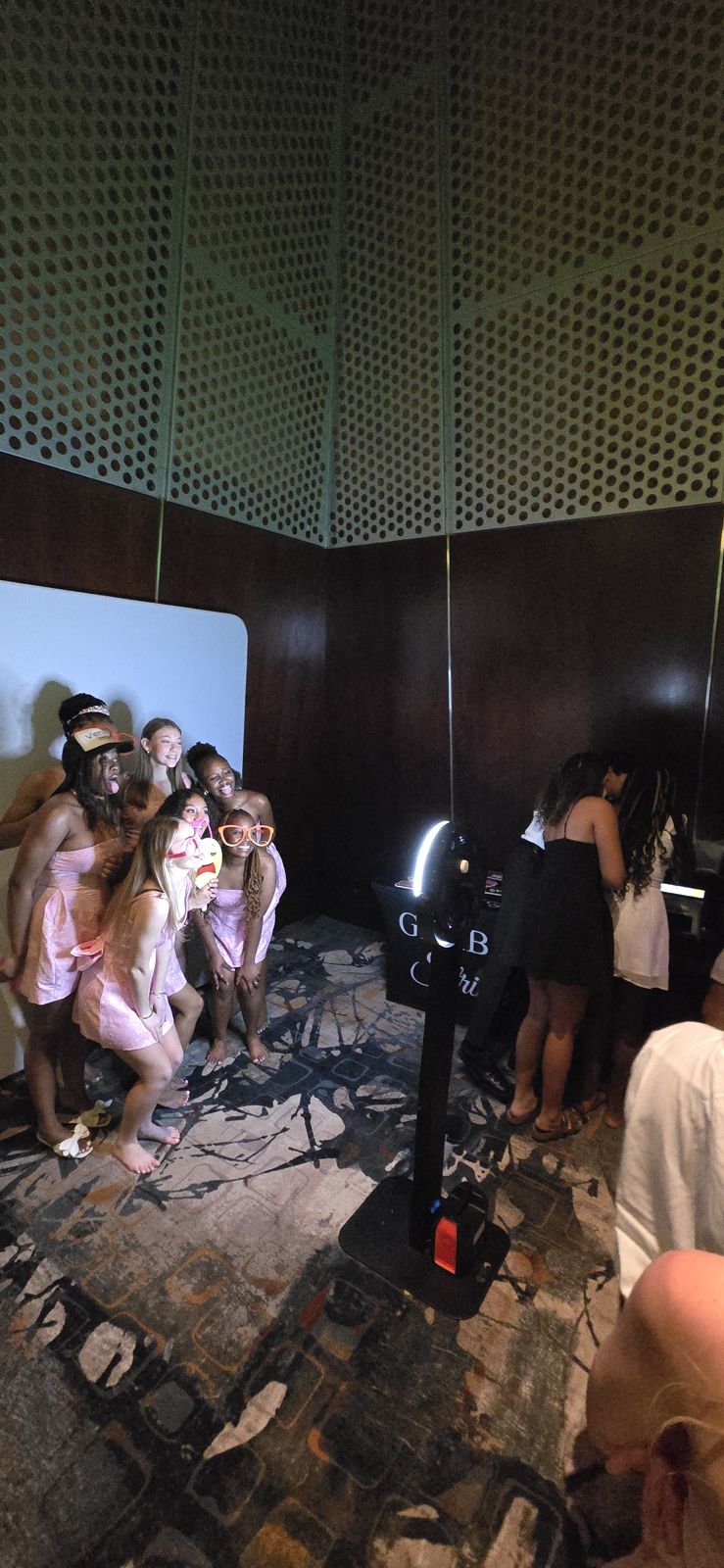 Guests posing at the Companion photo booth on a dance floor while friends watch