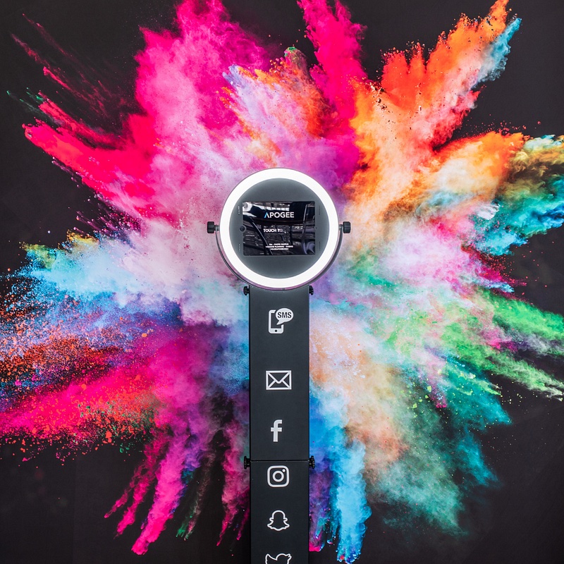Apogee Companion photo booth tower with ring light against a color-burst backdrop