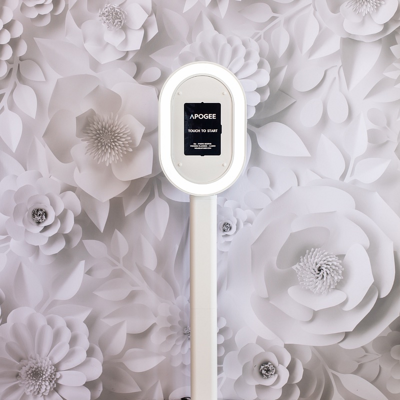 Apogee Princess photo booth with ring light in front of a white paper-flower wall