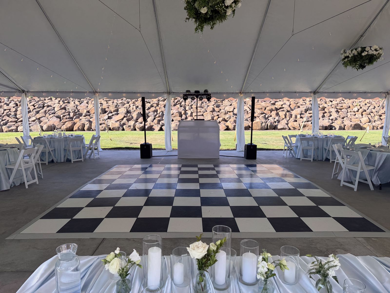 Tented wedding reception at West Hills Vineyards with a checkered dance floor, Apogee DJ booth, speakers, and dance lighting