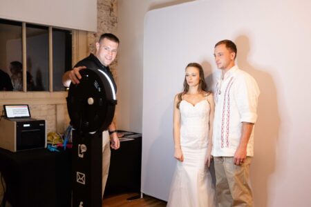 Zach Thomas from Apogee Event Productions at Willamette Heritage Center in Salem, Oregon takes photo booth pictures with a bride and groom.