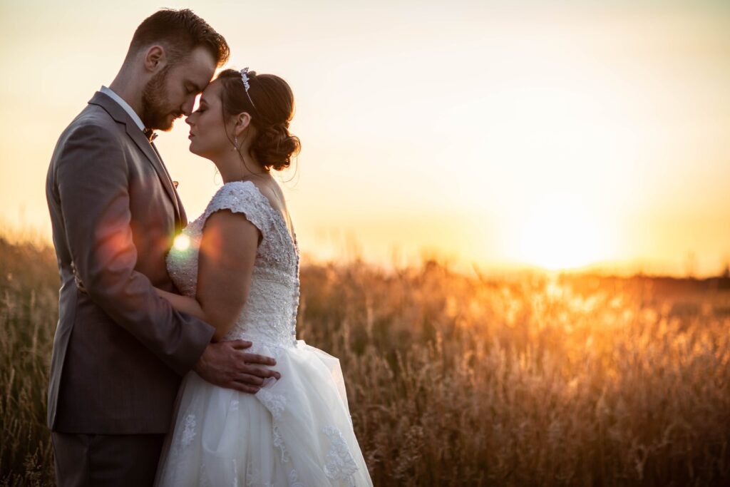 A couple in the sunset with a field behind them