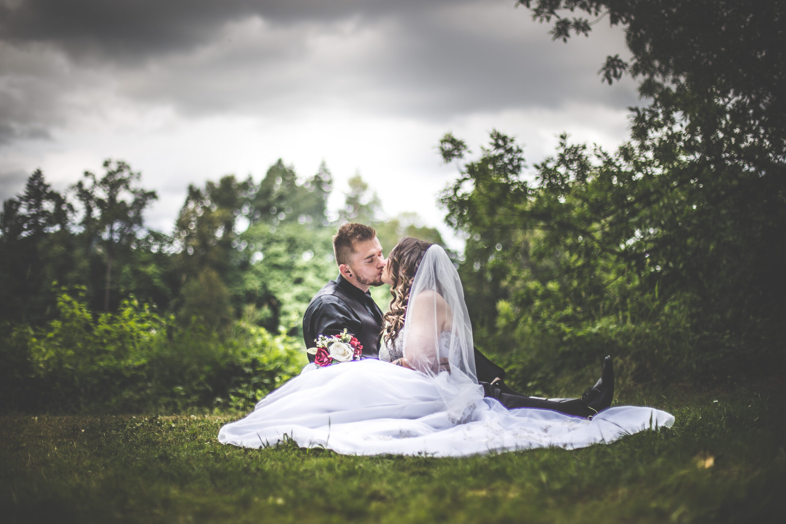 A wedding couple poses in a PNW setting holding a kiss
