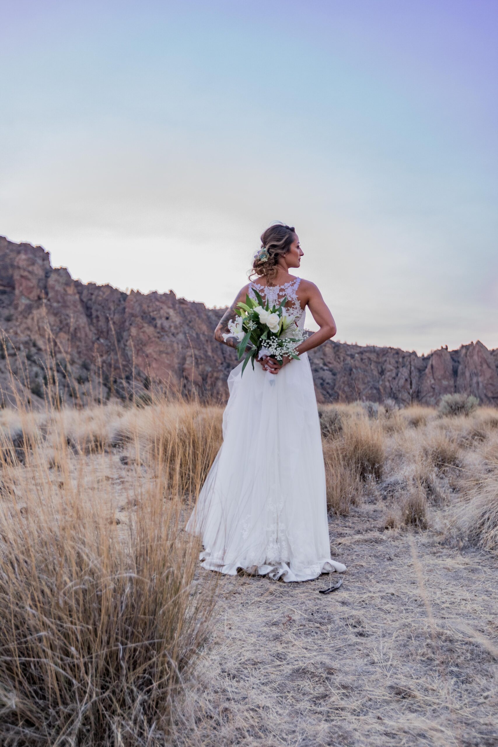 A bride poses at Smith Rock State Park, for her Oregon wedding. Oregon high desert as the background.