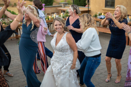 Bride surrounded by guests dancing and celebrating at outdoor Oregon wedding reception
