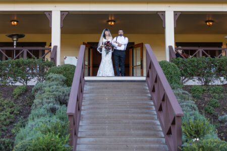 A father walks his daughter down the steps of zenith vineyard to get married