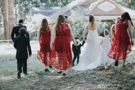 Full wedding party walking toward venue with bride in white gown Oregon outdoor wedding photography
